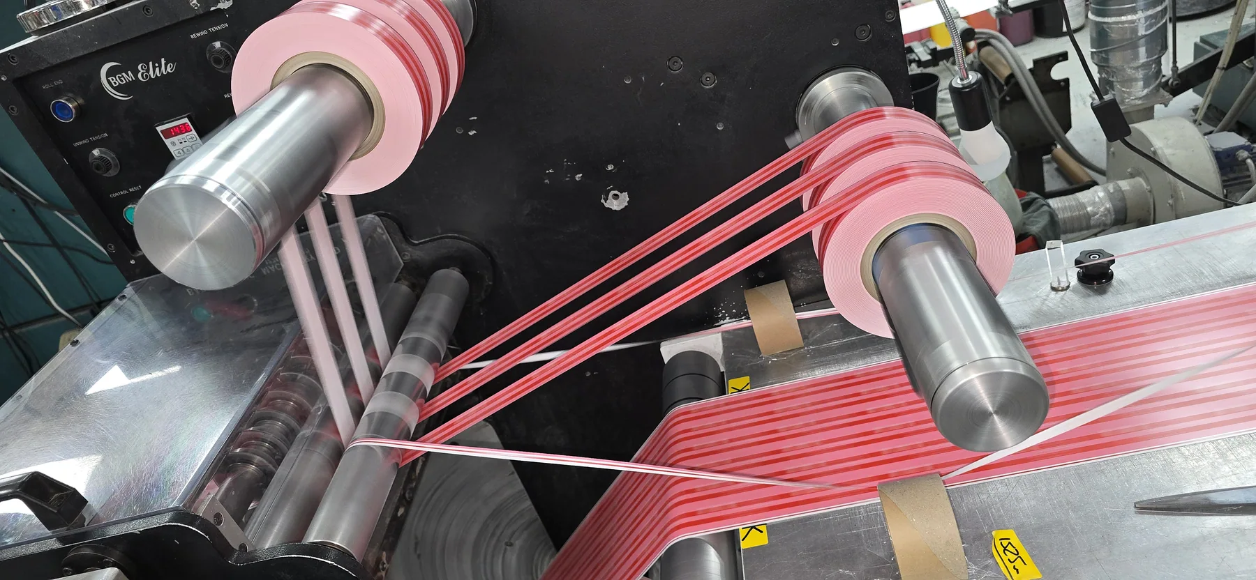 Red label material being slit and rewound in the factory